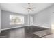 Living room features a large window, ceiling fan, and stylish, dark flooring at 1055 E Ingram St, Mesa, AZ 85203