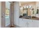 Bright bathroom with pool access, white cabinetry, and neutral countertops at 14420 N 44Th Dr, Glendale, AZ 85306