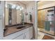 Traditional bathroom with wood-look countertops, large mirror, vanity lighting, and storage at 14420 N 44Th Dr, Glendale, AZ 85306