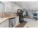 Galley-style kitchen with stainless steel appliances, neutral countertops, and a pass-through to the living room at 14420 N 44Th Dr, Glendale, AZ 85306