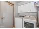Efficient laundry room with white washer, dryer, cabinets, and a convenient door for quick access at 14420 N 44Th Dr, Glendale, AZ 85306