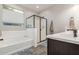 Bright bathroom featuring a soaking tub, walk-in shower with glass door, and modern vanity at 17866 W Lilac St, Goodyear, AZ 85338