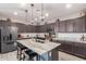 Modern kitchen featuring an oversized island with granite countertops, stainless steel appliances, and dark wood cabinetry at 17866 W Lilac St, Goodyear, AZ 85338