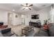 Spacious living room with comfortable leather seating, modern ceiling fan, and large television at 17866 W Lilac St, Goodyear, AZ 85338