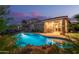 Sparkling pool with rock feature and swaying palms, creating a serene backyard oasis for leisure and enjoyment at 17866 W Lilac St, Goodyear, AZ 85338