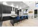 Modern kitchen with black cabinetry, waterfall island, counter seating, and stainless steel appliances at 1807 E Campbell Ave, Phoenix, AZ 85016
