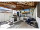 Outdoor kitchen with stainless steel appliances, TV, and pergola covered with lights at 1807 E Campbell Ave, Phoenix, AZ 85016