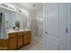 Bright bathroom with double sinks, wood cabinetry, a glass enclosed shower, and tile flooring at 21120 E Creekside Dr, Queen Creek, AZ 85142