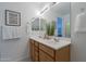 Bright bathroom featuring a double sink vanity, decorative mirror, and neutral tones at 21120 E Creekside Dr, Queen Creek, AZ 85142