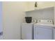 Laundry room with a shelf, a front load washer and dryer, and neutral walls at 21120 E Creekside Dr, Queen Creek, AZ 85142