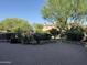 Landscaped backyard with mature trees, lush greenery, and a paved patio area at 22903 N 39Th Ter, Phoenix, AZ 85050