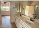 Well-lit bathroom featuring double sinks, granite countertops, and decorative mirrors at 22903 N 39Th Ter, Phoenix, AZ 85050