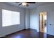 Well-lit bedroom features hardwood floors, a ceiling fan, and a doorway leading to additional rooms at 22903 N 39Th Ter, Phoenix, AZ 85050