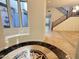 Spacious foyer showcasing elegant tile flooring, staircase, and tranquil courtyard view at 22903 N 39Th Ter, Phoenix, AZ 85050
