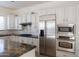 Modern kitchen boasts granite countertops, stainless steel appliances, and sleek white cabinets at 22903 N 39Th Ter, Phoenix, AZ 85050