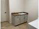 Functional laundry room with tile flooring, a utility sink, and neutral-colored cabinetry at 22903 N 39Th Ter, Phoenix, AZ 85050