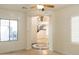 Bright living room featuring tile floors, a decorative medallion, and an archway leading to stairs and another room at 22903 N 39Th Ter, Phoenix, AZ 85050