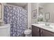 Cozy bathroom with a shower featuring a patterned curtain, a vanity with a sink, and decoratively displayed accents at 22920 E Indiana Ave, Queen Creek, AZ 85142