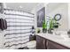 Bathroom featuring a shower with a patterned curtain, a vanity with a sink, and decorative plants at 22920 E Indiana Ave, Queen Creek, AZ 85142