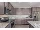 Contemporary kitchen with sleek appliances, ample counter space, and dark wood cabinets at 22920 E Indiana Ave, Queen Creek, AZ 85142