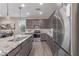 Modern kitchen featuring stainless steel appliances, granite countertops, and wood-look tile flooring at 22920 E Indiana Ave, Queen Creek, AZ 85142