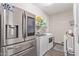 Modern laundry room equipped with stainless steel appliances and ample storage space, offering convenience at 22920 E Indiana Ave, Queen Creek, AZ 85142