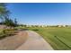 Community park view with green space, walking path, landscaping and neighborhood in the distance at 22920 E Indiana Ave, Queen Creek, AZ 85142