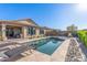 Relaxing backyard pool with lush landscaping, sun loungers, and covered patio at 22920 E Indiana Ave, Queen Creek, AZ 85142