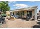 A backyard boasting an extended covered patio, ceiling fan, outdoor seating, dining area, and desert landscaping at 26247 W Lone Cactus Dr, Buckeye, AZ 85396