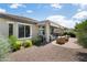 An exterior view shows a covered patio, awning, and desert landscaping that features rock ground cover and lush greenery at 26247 W Lone Cactus Dr, Buckeye, AZ 85396