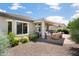 A rear view of the house highlighting the covered patio, extended awning and desert landscaping with rock ground cover at 26247 W Lone Cactus Dr, Buckeye, AZ 85396