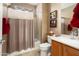 Cozy bathroom with a shower-tub combo, neutral-tone shower curtain, and a wood-trimmed vanity at 26247 W Lone Cactus Dr, Buckeye, AZ 85396