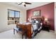 Comfortable bedroom with a wooden bed frame, decorative pillows, and a view of the outdoor patio at 26247 W Lone Cactus Dr, Buckeye, AZ 85396