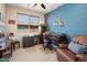 Well-lit home office with a large window, comfortable seating, and a dedicated workspace at 26247 W Lone Cactus Dr, Buckeye, AZ 85396