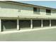 Close-up of multi-unit garages featuring dark-green doors, neutral colored building and landscaped surroundings at 30 E Brown Rd # 2113, Mesa, AZ 85201