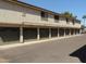 Multi-unit building featuring individual garages below living spaces, with dark-green doors and landscaped surroundings at 30 E Brown Rd # 2113, Mesa, AZ 85201