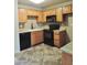 This kitchen features wooden cabinetry, black appliances, and granite countertops at 30 E Brown Rd # 2113, Mesa, AZ 85201