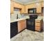 This kitchen features wooden cabinetry, black appliances, and granite countertops at 30 E Brown Rd # 2113, Mesa, AZ 85201