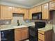 This kitchen features wooden cabinetry, black appliances, and granite countertops at 30 E Brown Rd # 2113, Mesa, AZ 85201
