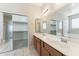 Bright bathroom with dual sinks, large mirror, and walk-in closet offers plenty of storage at 3310 W Chambers St, Phoenix, AZ 85041