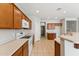 A bright kitchen featuring wooden cabinets, white appliances, and neutral countertops on tile floors at 3310 W Chambers St, Phoenix, AZ 85041