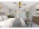 Relaxing main bedroom with a sitting bench, ceiling fan, and stylish decor at 3310 W Chambers St, Phoenix, AZ 85041