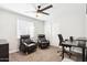 Spacious office area featuring a ceiling fan, large windows, and two comfortable black chairs at 3410 E Everett Dr, Phoenix, AZ 85032