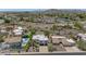 Aerial view of a property with a pool in a neighborhood surrounded by green trees, desert landscape, and mountains at 3611 E Ahwatukee Dr, Phoenix, AZ 85044