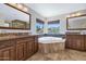 This bathroom features dual vanities, a soaking tub with stone accents, and mountain views at 3611 E Ahwatukee Dr, Phoenix, AZ 85044