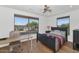 Sunny bedroom featuring hardwood floors, two large windows, and a ceiling fan at 3611 E Ahwatukee Dr, Phoenix, AZ 85044
