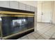 Close-up of the modern fireplace with tile surround, complemented by tiled flooring and a white front door at 4008 E Knox Rd, Phoenix, AZ 85044