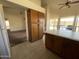 Bright eat-in kitchen featuring wood cabinets and tile flooring adjacent to a carpeted living area at 4008 E Knox Rd, Phoenix, AZ 85044