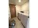Compact laundry room with a white washer and dryer unit and a wooden door at 4008 E Knox Rd, Phoenix, AZ 85044