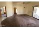 Spacious carpeted living room features a sliding glass door to the backyard and hallway access at 4008 E Knox Rd, Phoenix, AZ 85044